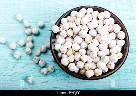 Les légumineuses pois chiches dans une assiette sur une table bleue défraîchie. Un espace réservé au texte Banque D'Images