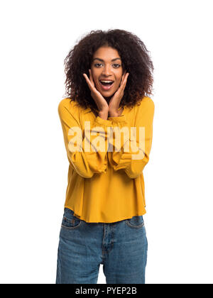 Belle african american woman with afro cheveux en souriant jaune d'usure, agréablement surpris à l'appareil photo sur mur blanc arrière-plan. Cute hispanic rif Banque D'Images