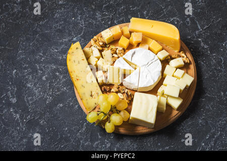 Différents types de fromage sur la table en pierre sombre. Banque D'Images