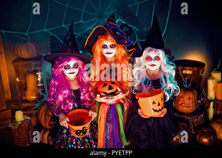 Trois belles filles dans un costume de sorcière. Funny sœurs célèbrent la maison de vacances. Jolly enfants en costumes de carnaval prêt pour l'Halloween dans halloween decorations Banque D'Images