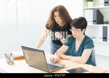 Les personnes, la technologie et de la communication concept - femme d'âge moyen et les jeunes femme travaillent ensemble Banque D'Images