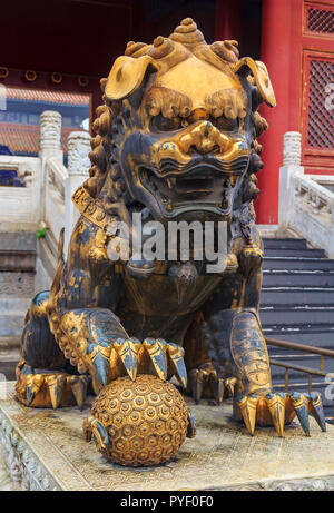 Close up d'une traditionnelle mâle doré lion gardien Impérial avec le symbole du monde qui a eu lieu sous sa patte dans la célèbre Cité Interdite, Beijing, Chi Banque D'Images