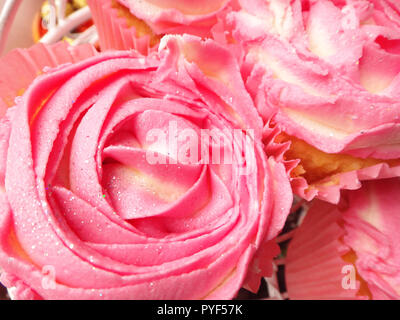Décorées muffins ou cupcakes avec rose ou rose en forme de fleur, glaçage au beurre dessert délicieux pour la Saint-Valentin ou une réception de mariage Banque D'Images
