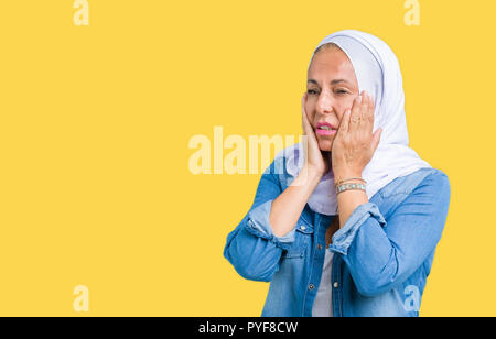 L'âge moyen est de l'arabe arabe femme portant le hijab sur fond isolé fatigué mains couvrant le visage, la dépression et la tristesse, colère, irrité et fo Banque D'Images