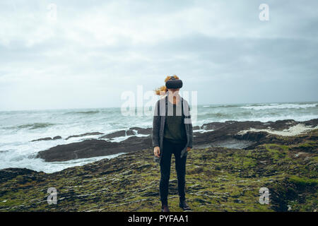 Femme à l'aide de casque de réalité virtuelle dans la plage Banque D'Images