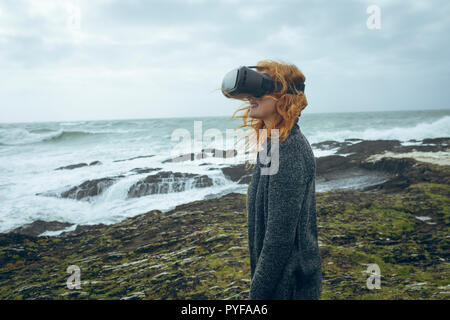 Femme à l'aide de casque de réalité virtuelle dans la plage Banque D'Images