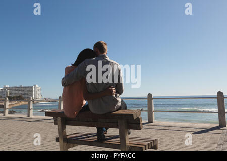 Couple assis sur un banc près de la plage Banque D'Images