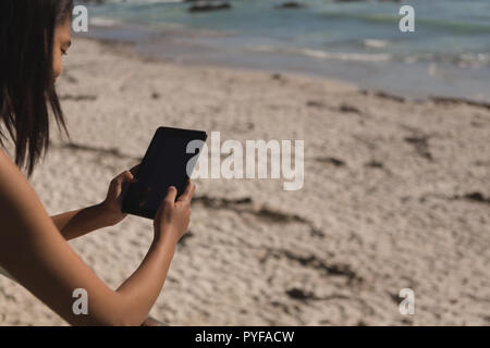 Woman using digital tablet près de la plage Banque D'Images