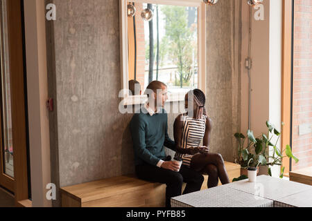 Couple en interaction les uns avec les autres dans le café Banque D'Images