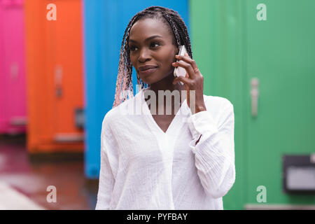 Jeune femme à la mode de parler sur le téléphone mobile Banque D'Images