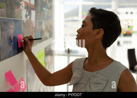 Chef d'entreprise écrit le post-it in office Banque D'Images