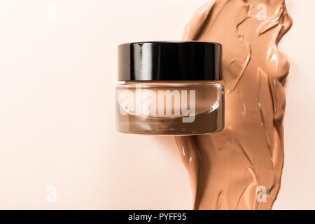 Un bocal de verre de base d'un visage avec un échantillon du produit lui-même. Banque D'Images