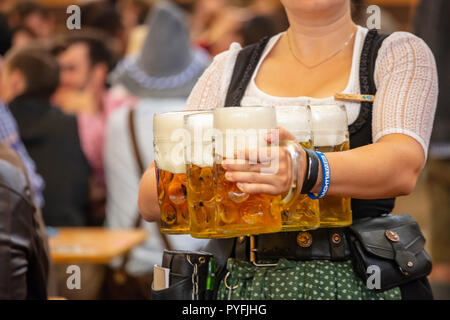 L'Oktoberfest, Munich, Allemagne. Femme garçon avec costume traditionnel holding beers Banque D'Images