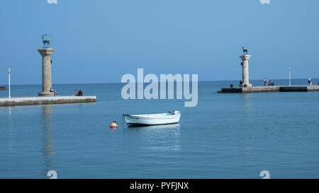 L'entrée du petit port de Rhodes, Grèce, avec les deux piliers Elafos Elafina et montrant à la fois les emblèmes de l'île Banque D'Images