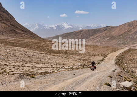 Le cycliste pédale chargé remote 4,340m Khargush passer entre Langar et Alichur, Pamir Highway, Haut-badakhchan, Tadjikistan Banque D'Images