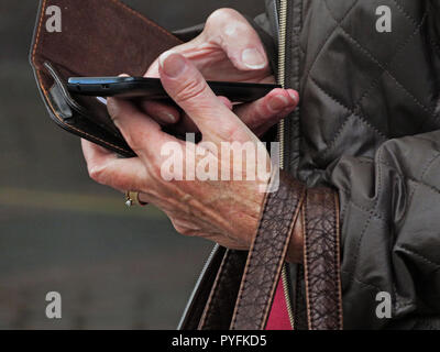 Gros plan du téléphone mobile en utilisant les doigts de femme à l'aéroport de Leeds Bradford West Yorkshire Angleterre Yeadon Banque D'Images