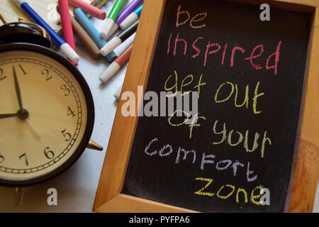 S'inspirer de sortir de votre zone de confort expression manuscrite colorés sur tableau, réveil avec motivation et concepts d'éducation Banque D'Images