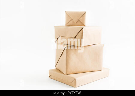 Pile de boîtes enveloppées d'artisanat pour la livraison sur fond blanc Banque D'Images