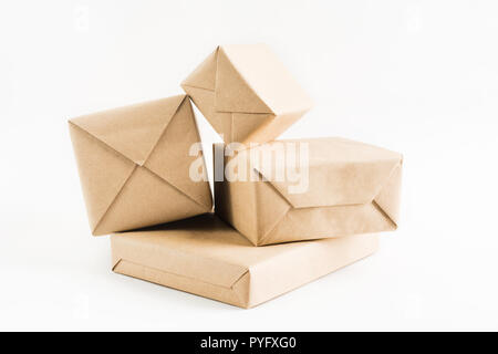 Pile de boîtes enveloppées d'artisanat pour livraison sur fond blanc Banque D'Images