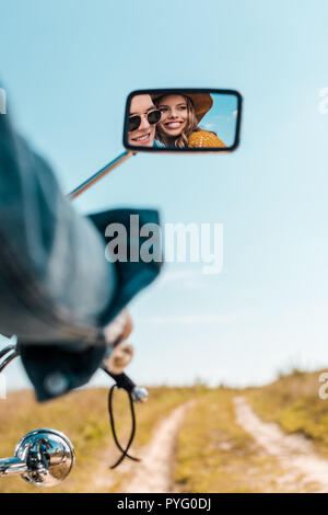 La réflexion de l'heureux couple dans rétroviseur de moto Banque D'Images