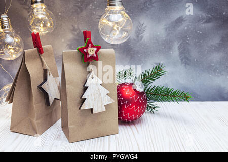 Sacs-cadeaux en papier décoratif rouge et balle avec des lampes rétro et vert sapin de Noël de la direction générale contre l'arrière-plan Banque D'Images