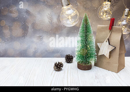 Décoration de Noël avec des petits faux arbre vert, sac cadeau papier et vieille lampe guirlandes Banque D'Images