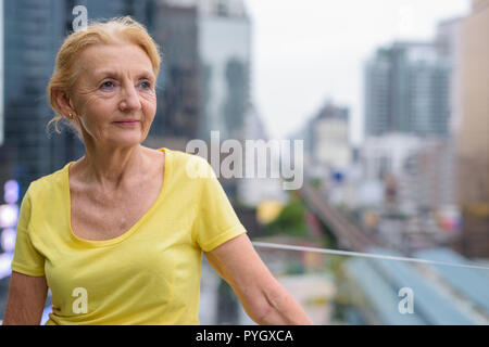 Belle pensée senior woman outdoors in city Banque D'Images