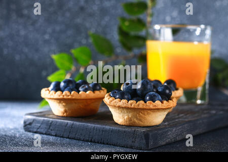 Les baies de sable bleu prunellier dans tartelettes sur une table Banque D'Images