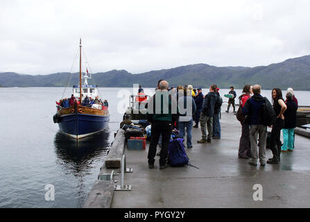 Le seul mode de transport pour le petit village de Knoydart, qui se trouve sur le bord de la péninsule de Knoydart, est un bateau, en venant ici à Mallaig, comme il n'y a pas de route qui accède au petit hameau et ces visiteurs sont en attente d'embarquer et ensemble de la faune sur leur aventure ! Banque D'Images