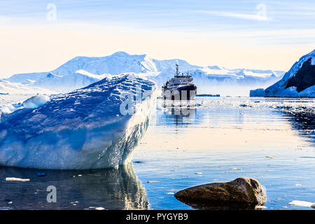 Bateau de croisière antarctique touristiques parmi les icebergs avec glacier en arrière-plan, la baie de Neco, Antarctique Banque D'Images