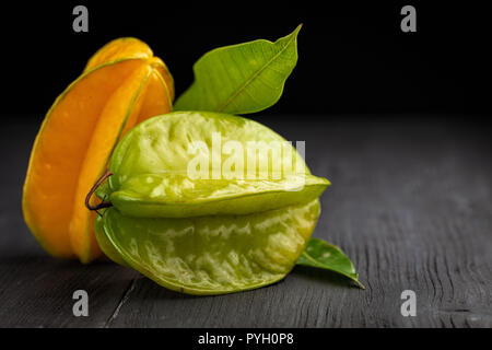 Venu de jaune et de vert carambole carambole ou étoile ( apple ) caramboles sur fond de bois foncé Banque D'Images