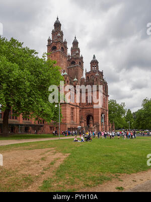 Profitant de la chaleur de l'été Glaswegians dans l'herbe à l'extérieur de l'entrée du musée de Kelvingrove à Glasgow, Écosse, Royaume-Uni. Banque D'Images