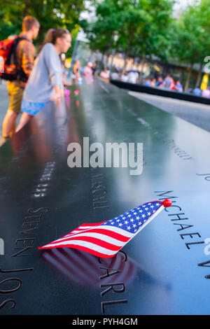 Les noms de certaines victimes marqués par le drapeau américain sur le 11 septembre 2001 World Trade Center Memorial des fontaines dans le Lower Manhattan, New York City Banque D'Images