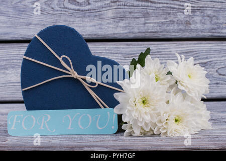 Fond romantique avec fleurs et boîte-cadeau. Valentines Day background avec présent fort en forme de cœur et de beaux chrysanthèmes sur t en bois Banque D'Images