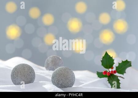 Décoration de Noël d'argent, de trois balles dans la neige sur le fond de carte de Vœux Lumières floues Banque D'Images