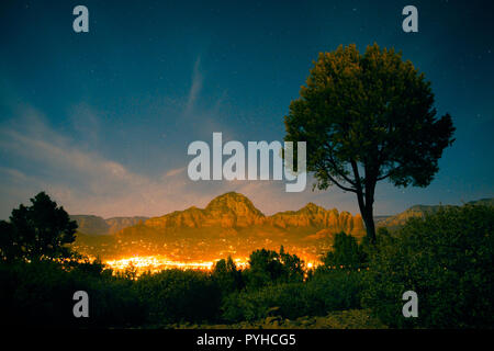 Belle scène de nuit de Sedona Arizona avec des formations rocheuses des montagnes et les lumières de la ville Banque D'Images