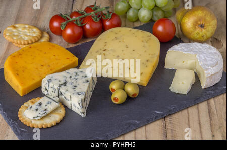Plateau de fromages aux trois fromages Gouda, avec pimento, gouda avec les graines de cumin et fromage bleu roquefort et camembert close up on rustique en background Banque D'Images