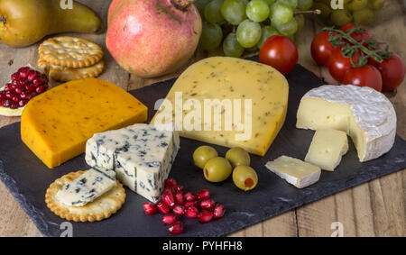Plateau de fromages aux trois fromages Gouda, avec pimento, gouda avec les graines de cumin et fromage bleu roquefort et camembert close up on rustique en background Banque D'Images