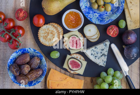 Plateau de fromages aux trois fromages Gouda, avec pimento, gouda avec les graines de cumin et roquefort fromage bleu et fruits assortis close up on rustique en b Banque D'Images