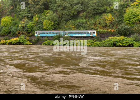 RADYR, près de Cardiff, Pays de Galles - 13 octobre 2018 : train de banlieue près de Radyr, Cardiff, Pays de Galles du Sud en passant le Brown de l'eau boueuse de la rivière Taff en fl Banque D'Images