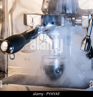 Photo spectaculaire d'une machine à expresso avec production de vapeur et de la vapeur d'eau ; concepts : cafe, café, espresso, cappuccino, latte, barista Banque D'Images