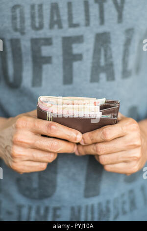 Close up of hands holding un portefeuille avec de l'argent Banque D'Images
