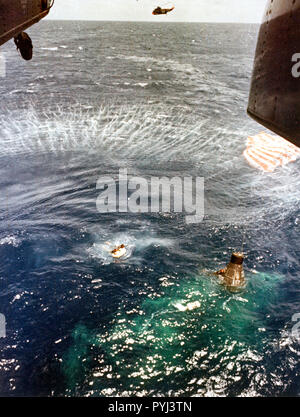 (16 mai 1963) --- UN U.S. Navy frogman, déployés à partir de l'hélicoptère en vol stationnaire, nage à côté de la sonde et est en contact avec l'astronaute Gordon Cooper Jr. L. à l'intérieur, comme ses collègues membres de l'équipe faire apparaître le pignon de flottaison pour être attaché à l'engin spatial. Banque D'Images