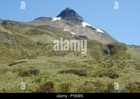 Pyramid Peak, s'élevant au-dessus de l'herbe de prairie de montagne, sur l'île d'Unalaska, archipel des Aléoutiennes, Alaska, United States. Banque D'Images