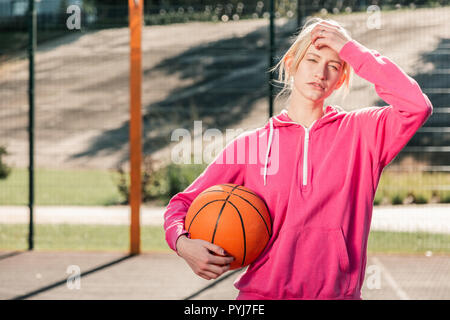 Beau jeune blond woman wearing sportswear rose Banque D'Images