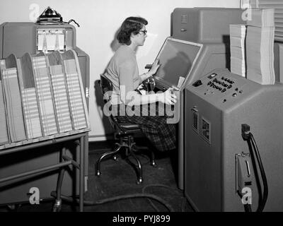 Un membre du personnel de la Section d'informatique au National Advisory Committee for Aeronautics (NACA) Lewis Flight Propulsion Laboratory exploite un International Business Machines (IBM) telereader à la 8- par 6 pieds de soufflerie supersonique. Banque D'Images