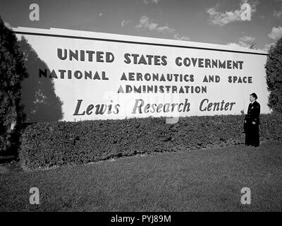 Un garde de sécurité examine le nouveau panneau près de l'entrée du Centre de recherche Lewis un jour après que la National Aeronautics and Space Administration (NASA) a été officiellement créé. La NASA a été mise en place le 1er octobre 1958, et le National Advisory Committee for Aeronautics (NACA) Lewis Flight Propulsion Laboratory de la NASA Lewis est devenu le centre de recherche. Banque D'Images