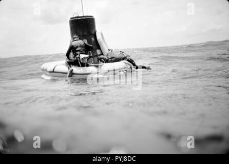 (16 mai 1963) --- Une équipe de l'US Navy frogman attache un collier à la flottaison Mercury-Atlas 9 (MA-9)'foi 7' engin spatial pendant des opérations de valorisation dans le centre du Pacifique près de l'île de Midway. Banque D'Images