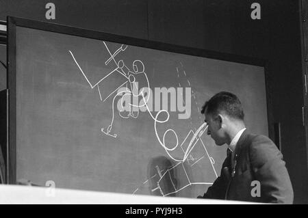 (1) Août 1966 --- L'astronaute John W. Young, Gemini-10 pilote de commande, utilise un dessin à la craie sur un tableau noir pour illustrer comment l'astronaute Michael Collins, Gemini-10 pilote, quand il a inspecté le véhicule d' cible Agena durant son activité extravéhiculaire. Banque D'Images