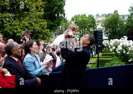 Le président Barack Obama lève un bébé tout en respectant le personnel de l'Ambassade américaine après son arrivée à la résidence de l'ambassadeur à Caen, France, 6 juin 2009. Banque D'Images